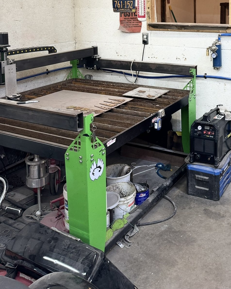The shop's own 60 by 72 inch CNC plasma cutting table, steel plate loaded and ready to cut