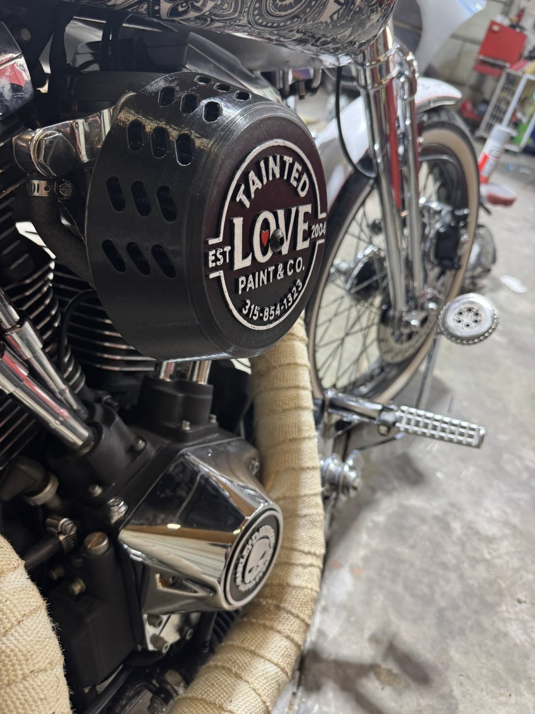 Custom 3D-printed Tainted Love Paint and Co air cleaner cover badge mounted on a motorcycle engine